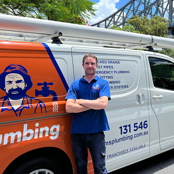 Rhys standing next to Jim's van with Story Bridge in background