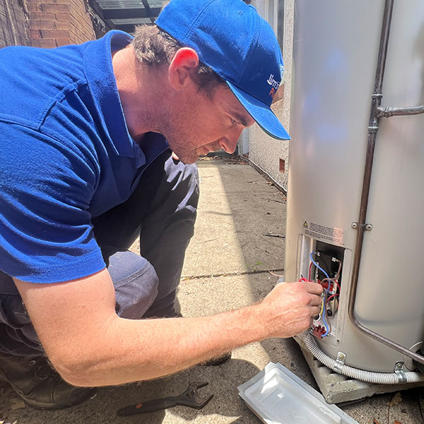 Rhys fixing an outdoor electric hot water system