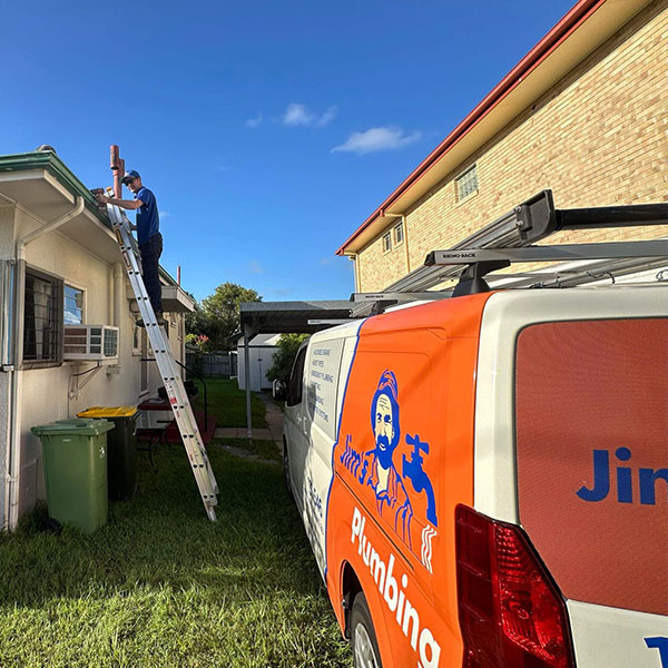 Far shot of Jim's van with Rhys up on ladder fixing gutters