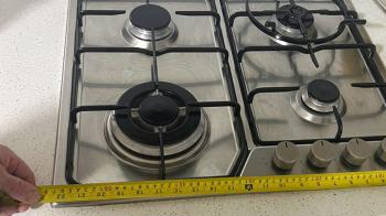 Rhys measuring a gas oven stovetop for installation