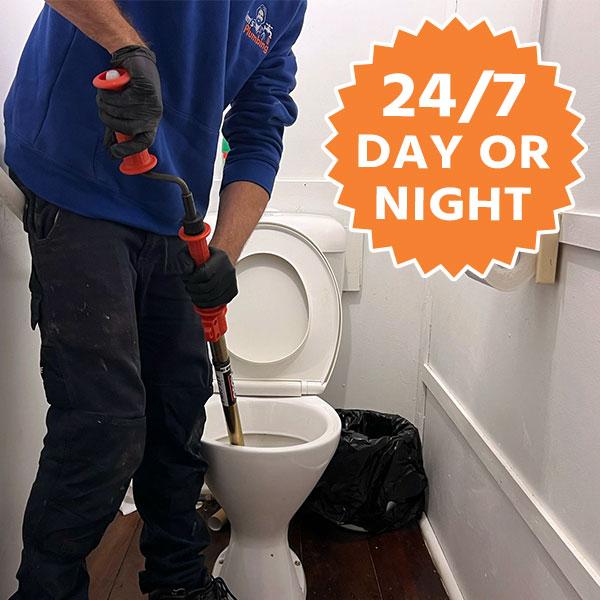 Plumber using a plunger to unblock a toilet