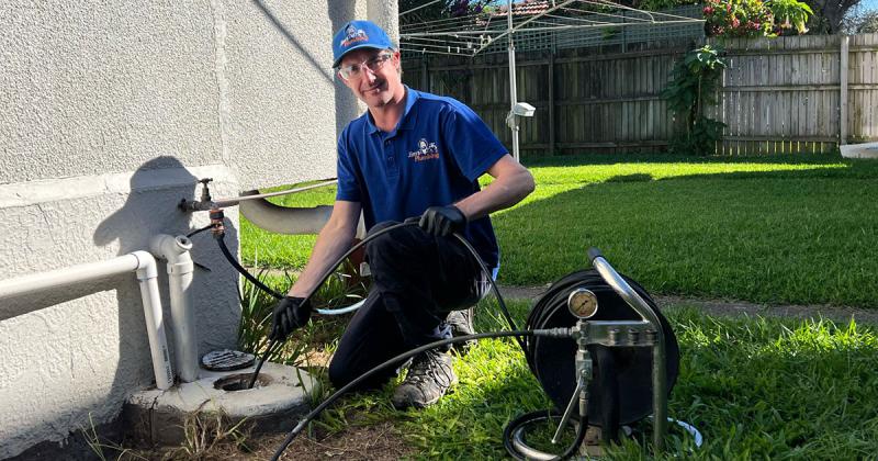 Rhys using a hydrojet to clean outdoors stormwater drain at property in Margate, Brisbane.