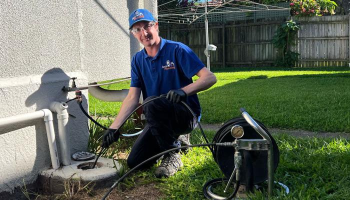 Rhys using a hydrojet to clean outdoors stormwater drain at property in Margate, Brisbane.